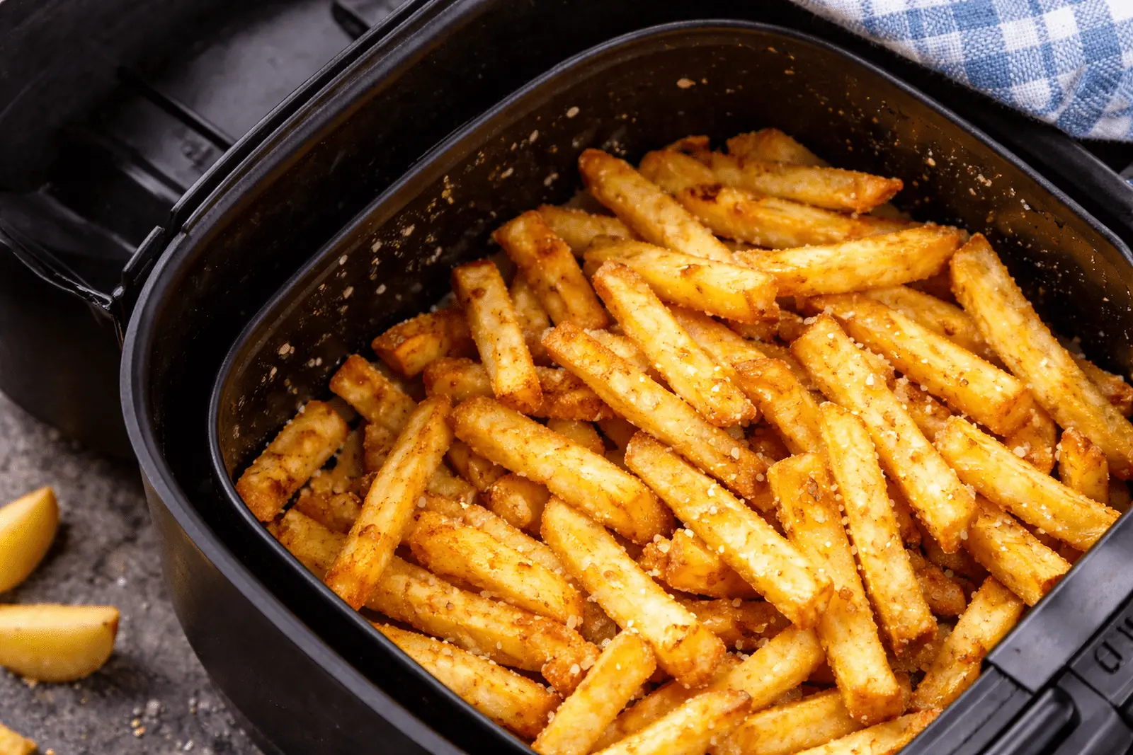 Goldbraune Tiefkühlpommes im Airfryer-Korb, knusprig gebacken bei 180 bis 190 Grad.